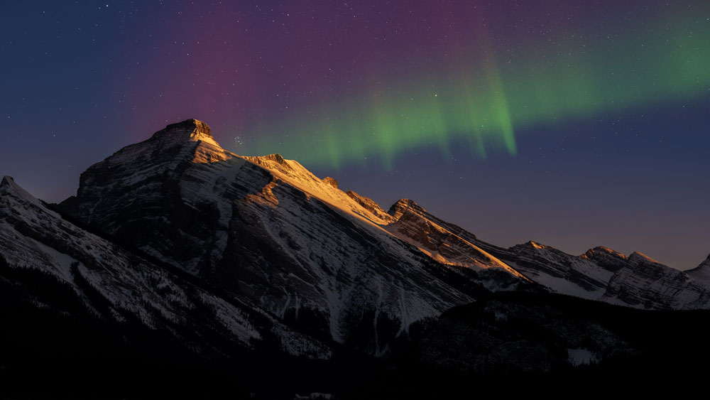 aurora over mountains at sunset